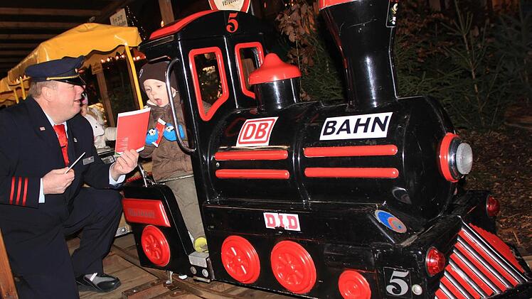 Peter Dauth schickt die erste Bahn auf die Strecke. Zuvor beschenkt er die Kinder noch mit Süßigkeiten und Malbüchern. Foto: Matthias Einwag
