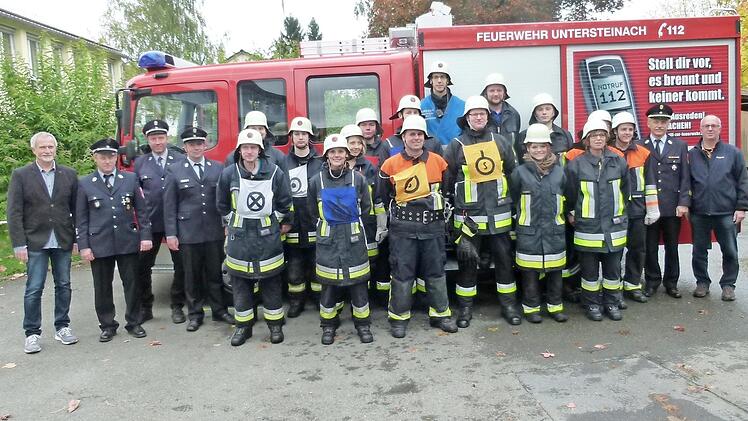 Die Aktiven mit (von links) Zweitem Bürgermeister Hans-Peter Röhrlein, Schiedsrichter Jürgen Müller, Kommandanten Daniel Nöske und Kreisbrandmeister Alexander Reinsch sowie (von rechts) Bürgermeister Stephan Heckel-Michel und Kreisbrandinspektor Horst Tempel