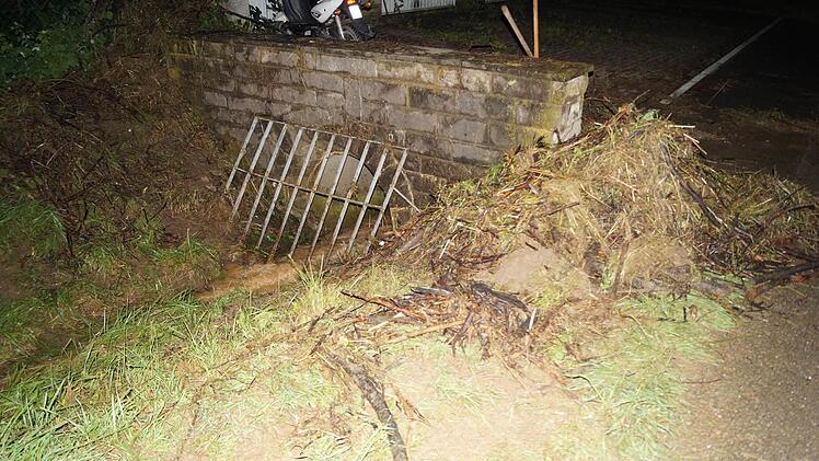 Hier sollte das Wasser von den Feldern in die Kanalisation fließen. Daneben türmt sich das angeschwemmte Material, das die Einsatzkräfte aus dem Durchfluss entfernten.  Foto: Peter Schmieder