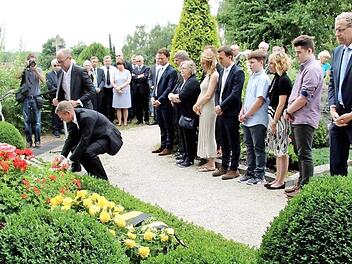 Frank Dassler (stehend) und Harm Ohlmeyer legten im Namen der Firma Adidas einen Kranz am Familiengrab nieder. Foto: Richard Sänger