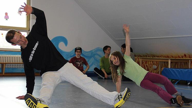 Sven Weiß, der in Harsdorf einen Breakdance-Kurs gibt, vermittelt den Kindern viel Spaß, aber auch eine gehörige Portion Fitness. Hier feilt er gerad e mit Klara an ihrem Solo. Foto: Katharina Müller-Sanke