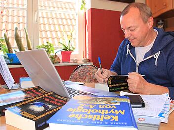 Werner Karl in seinem Wohnzimmer, wo er am Laptop seine Fantasy-Romane verfasst. Foto: Matthias Einwag