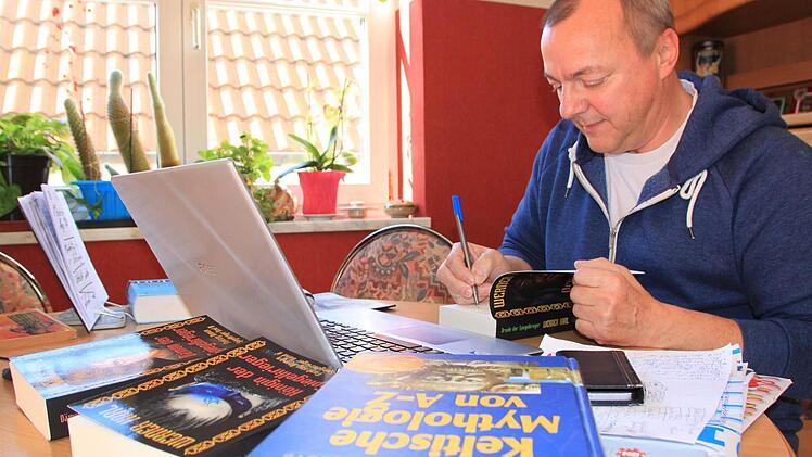 Werner Karl in seinem Wohnzimmer, wo er am Laptop seine Fantasy-Romane verfasst. Foto: Matthias Einwag