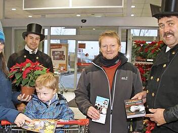 Die Schornsteinfeger Florian und Harald Will bringen wirklich Glück, wie diese Familie erleben konnte. Denn kaum hatte sie am Glücksrad gedreht, gewann sie auch schon einen Rauchmelder - zusätzlich zum Weihnachtsstern. Der Erlös der Sammelaktion geht an den Verein "Schornsteinfeger helfen krebskranken Kindern". 1200 Euro haben Florian und Harald Will für den guten Zweck gesammelt. Foto: Sonny Adam