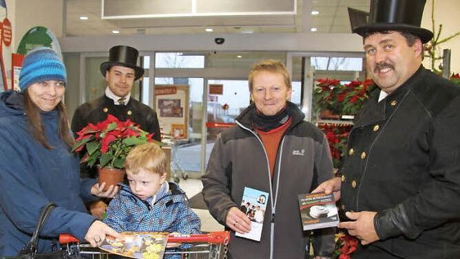 Die Schornsteinfeger Florian und Harald Will bringen wirklich Glück, wie diese Familie erleben konnte. Denn kaum hatte sie am Glücksrad gedreht, gewann sie auch schon einen Rauchmelder - zusätzlich zum Weihnachtsstern. Der Erlös der Sammelaktion geht an den Verein "Schornsteinfeger helfen krebskranken Kindern". 1200 Euro haben Florian und Harald Will für den guten Zweck gesammelt. Foto: Sonny Adam