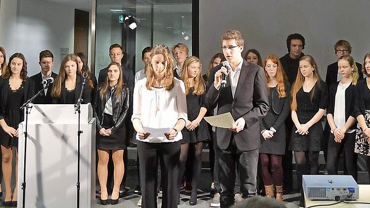 Kilian Hacker (am Mikrofon) und die 9b des Herzogenauracher Gymnasiums bei der Schlussrede der szenischen Lesung am 27. Januar im Erlanger Rathaus  Fotos: privat