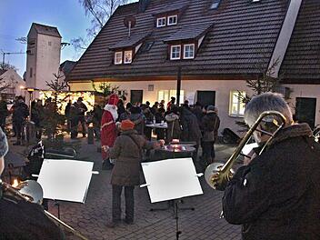 Dem Posaunenchor Rentweinsdorf über die Schulter geblickt - im Hintergrund Besucher des Weihnachtsmarktes mit dem Nikolaus. Foto: Helmut Will