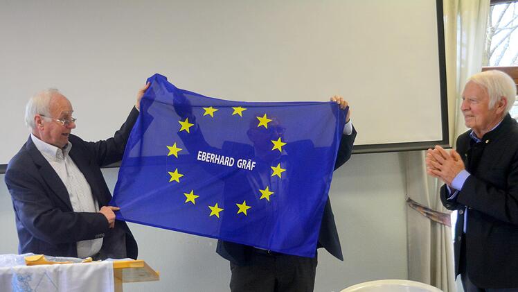 Alfred Wacker, fr&uuml;herer Bad Kissinger  B&uuml;rgermeister, &uuml;bergibt Eberhard Gr&auml;f eine Europafahne als Abschiedsgeschenk. Foto: Arthur Stollberger