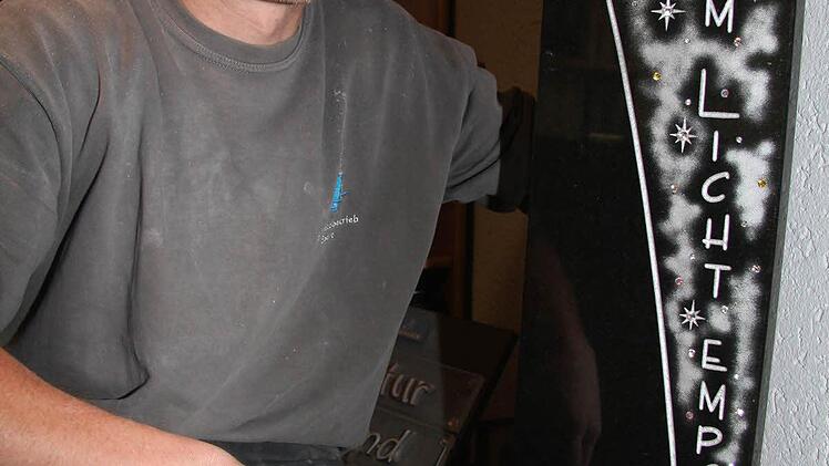 Marco Ebert zeigt die neuesten Trends auf dem Friedhof: Grabsteine mit eingearbeiteten funkelnden Swarowskisteinen.