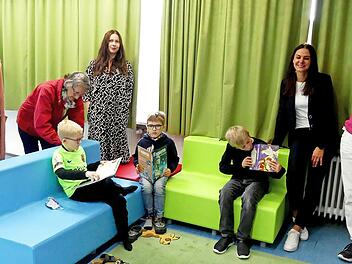 Tyler, Ben und Jakob (von rechts) nutzen die neuen Sitzmöbel in der Leseecke zum Schmöckern in ihren Lieblingsbüchern. Davon konnte sich das Kiwanis-Team überzeugen (von rechts): Präsidentin Anja Gimpel-Henning, stellvertretende Schulleiterin Julia Bimsner, Vizepräsidentin Anna Müller, Sekretär Rosi Müller (bei Kiwanis heißt es Sekretär, egal ob die Position männlich oder weiblich besetzt ist), Pastpräsidentin Sabine Kretschmar.