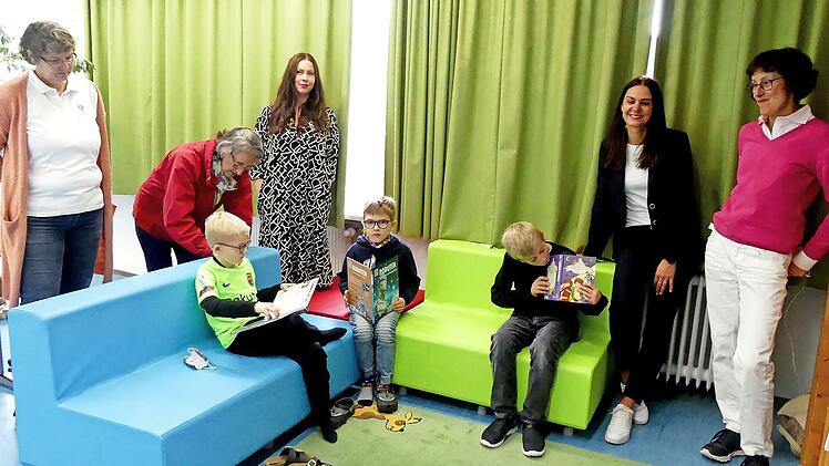 Tyler, Ben und Jakob (von rechts) nutzen die neuen Sitzmöbel in der Leseecke zum Schmöckern in ihren Lieblingsbüchern. Davon konnte sich das Kiwanis-Team überzeugen (von rechts): Präsidentin Anja Gimpel-Henning, stellvertretende Schulleiterin Julia Bimsner, Vizepräsidentin Anna Müller, Sekretär Rosi Müller (bei Kiwanis heißt es Sekretär, egal ob die Position männlich oder weiblich besetzt ist), Pastpräsidentin Sabine Kretschmar.