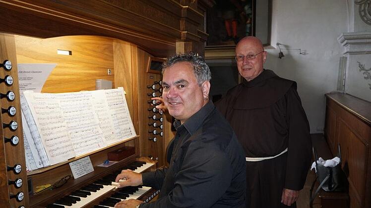 Christoph Brückner präsentierte an der Orgel in der Klosterkirche am Kreuzberg sein Konzertprogramm "Organissimo". Pater Georg Andlinger ließ sich von ihm seine Variationen zu bekannten Kirchenliedern erläutern. Marion Eckert