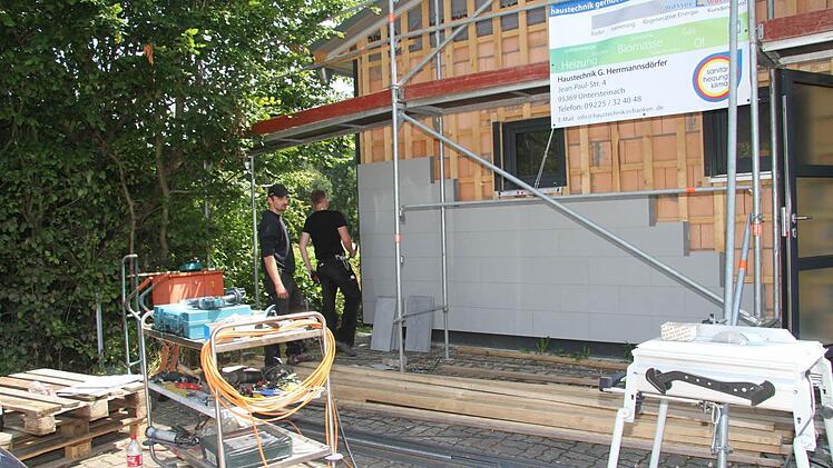 Mark Trapper und Alexander Schuberth verkleiden das Schützenhaus mit Faserzementplatten.
