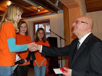 Ministranten überreichen Pfarrer Scherbel ein Geschenk.