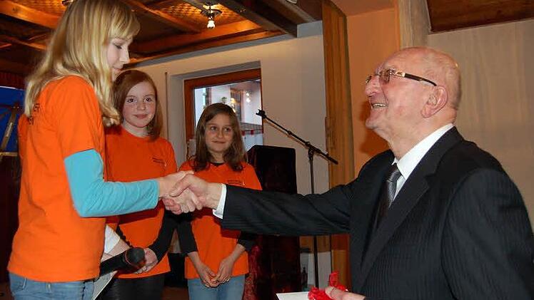 Ministranten überreichen Pfarrer Scherbel ein Geschenk.