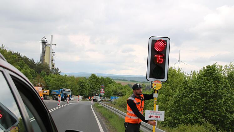 Matthias Wörner von der Firma Ortner richtet die neue Baustellenampel mit Countdown ein. Das ist eine Premiere in Franken. Foto: Thomas Malz