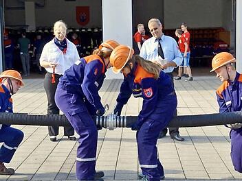 Die Stralsbacher Truppe ist hier beim Kuppeln einer Saugleitung. Niklas Grom (links)und Jonathan Wehner halten die Enden, die beiden Mädchen Lisa Schlereth (Mitte rechts) und Vanessa Karch verbinden die Schläuche. Die beiden Schiedsrichter Christine Felle und Steffen Voll zeigen sich zufrieden damit. Fotos: Kathrin Kupka-Hahn