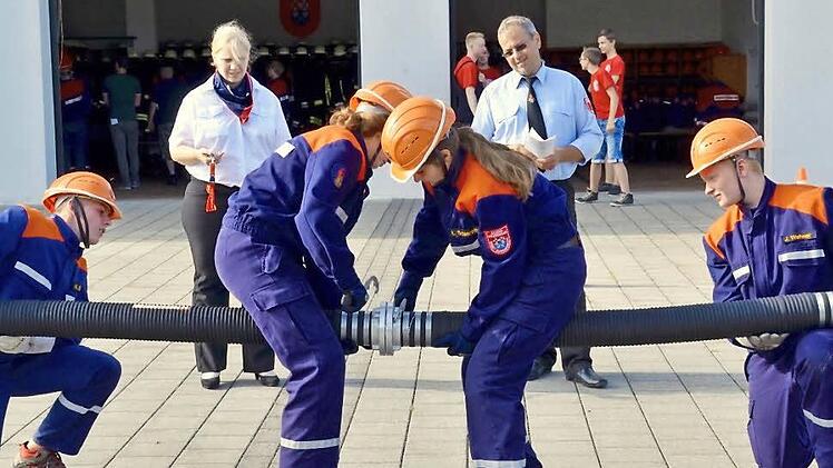 Die Stralsbacher Truppe ist hier beim Kuppeln einer Saugleitung. Niklas Grom (links)und Jonathan Wehner halten die Enden, die beiden Mädchen Lisa Schlereth (Mitte rechts) und Vanessa Karch verbinden die Schläuche. Die beiden Schiedsrichter Christine Felle und Steffen Voll zeigen sich zufrieden damit. Fotos: Kathrin Kupka-Hahn