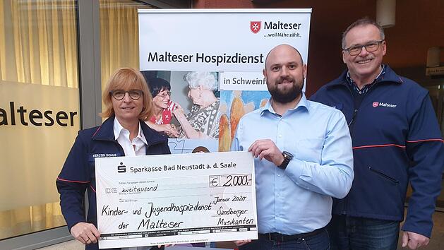 Die Sandberger Musikanten spendeten 2000 Euro f&uuml;r die Kinderhospizarbeit. Unser Foto zeigt Lukas Neumann von den Sandberger Musikanten (Mitte) bei der Scheck&uuml;bergabe an die Malteser, vertreten durch Kerstin Schug (links) und Norbert Wahler (rechts). Foto: Monika Spath/Malteser