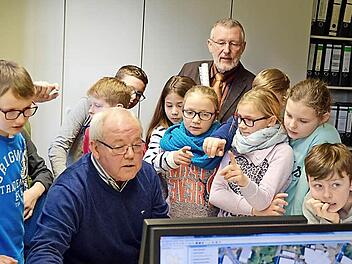 Georg Köth von der Bauverwaltung zeigt den Kindern der 4. Klasse aus Lauter und Bürgermeister Waldemar Bug (hinten) am Bildschirm verschiedene Grundstückspläne. Foto: Kathrin Kupka-Hahn