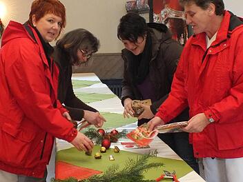 Gudrun Rathgeber, Annette Beck-Schlembach, Bianca Schneider und Christine Eppler (von links) schmücken die Tische für die Weihnachtsfeier im Pfarrsaal in Bad Bocklet.  Foto: Björn Hein