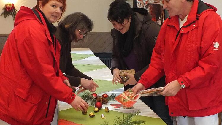 Gudrun Rathgeber, Annette Beck-Schlembach, Bianca Schneider und Christine Eppler (von links) schmücken die Tische für die Weihnachtsfeier im Pfarrsaal in Bad Bocklet.  Foto: Björn Hein