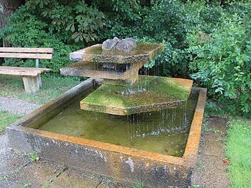 Dieser Betonplattenbrunnen aus den 70er-Jahren ist unansehnlich geworden und soll durch einen Trog mit Röhrensäule ersetzt werden. Foto: Matthias Einwag