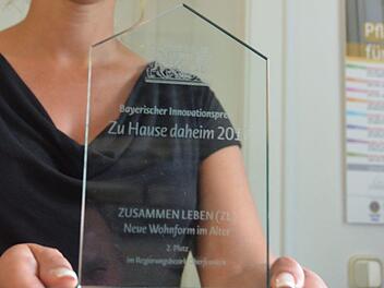 Kristin Herbst zeigt den Preis, den das Projekt "Zusammen leben" bekommen hat. Foto: Rainer Lutz
