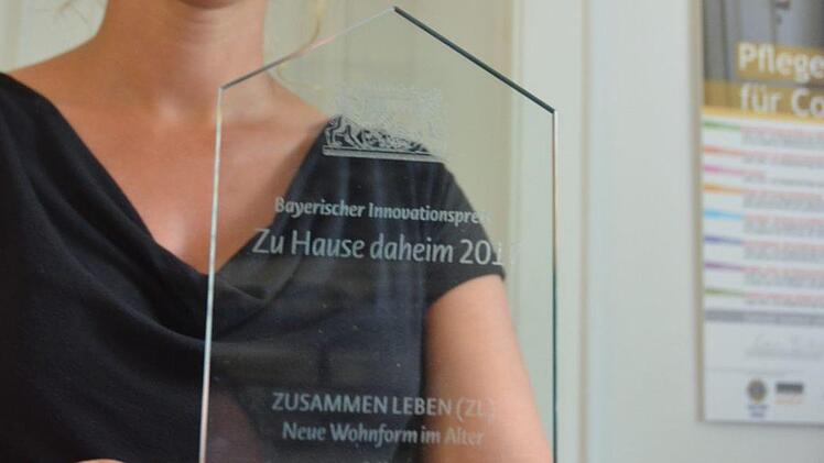 Kristin Herbst zeigt den Preis, den das Projekt "Zusammen leben" bekommen hat. Foto: Rainer Lutz