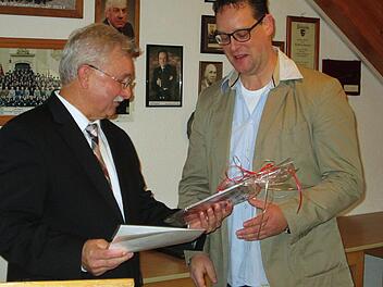 Bürgermeister Peter Hart (links) zeichnet Tobias Pfülb, der seit gut zehn Jahren den Fuschter Musikanten vorsteht, mit dem Glaswappenteller aus.  Winfried Ehling