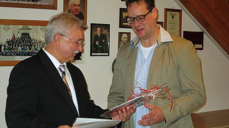 Bürgermeister Peter Hart (links) zeichnet Tobias Pfülb, der seit gut zehn Jahren den Fuschter Musikanten vorsteht, mit dem Glaswappenteller aus.  Winfried Ehling