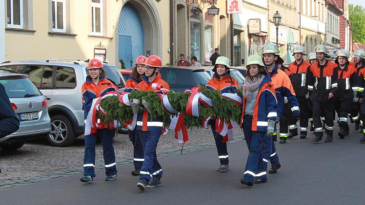 Die Jugendfeuerwehr trägt den Kranz, der an der Spitze des Baumes befestigt wird. Foto: Becht
