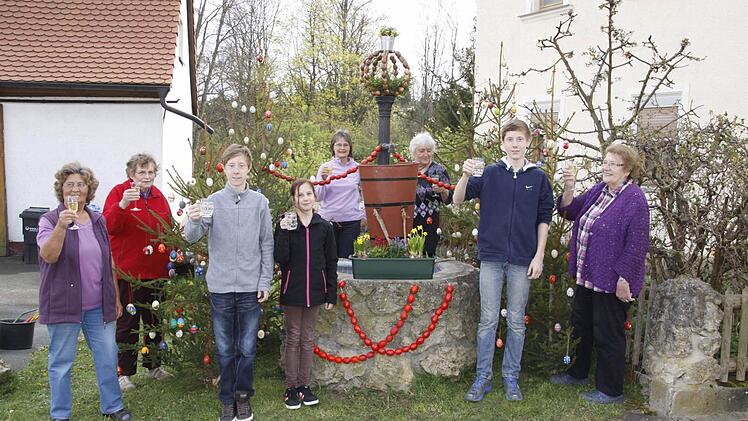 Die "Haacher" stoßen darauf an, dass ihr Osterbrunnen mit 105 Jahren der Älteste in der Fränkischen Schweiz ist. Mitgeholfen haben unter anderem Elfriede und Julian Herzer, Luise Hofmann, Anneliese Nüßlein, Christine Ott und die Familie Wengert.  Foto: Reinhard Löwisch
