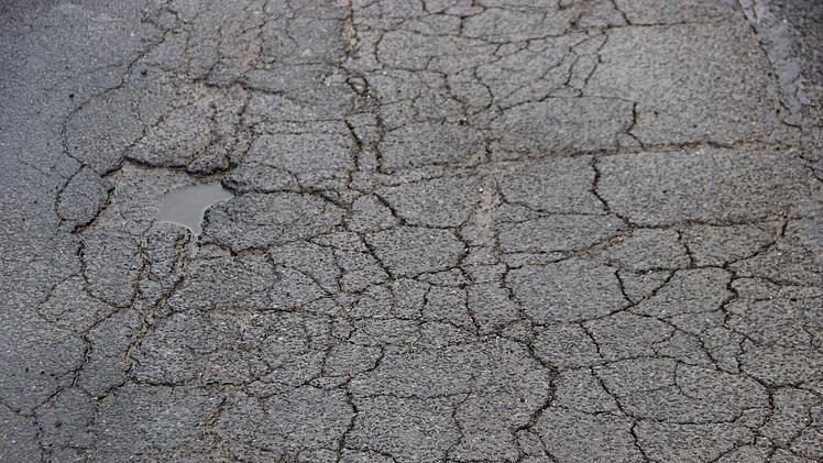 Risse überziehen die Asphaltdecke im   Münnerstädter Schwimmbadweg.Heike Beudert