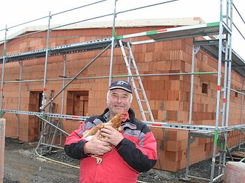 Bio-Landwirt Fritz Rösch aus Poppenholz zeigt seinem Lieblingshuhn Frieda den neuen Stall, wo bald die neuen 2700 Hennen einziehen werden. Foto: Sonja Adam