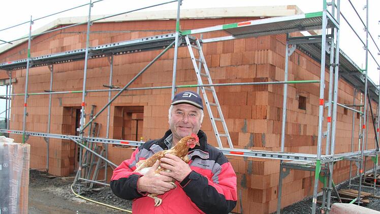 Bio-Landwirt Fritz Rösch aus Poppenholz zeigt seinem Lieblingshuhn Frieda den neuen Stall, wo bald die neuen 2700 Hennen einziehen werden. Foto: Sonja Adam