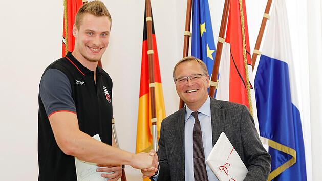 Oberb&uuml;rgermeister Andreas Starke (r.) &uuml;berreichte an Leon Radosevic nicht nur die Einb&uuml;rgerungsurkunde, sondern auch einen Bamberger Bildband. Foto: Daniel L&ouml;b