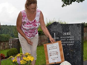 Lydia Muth hat sogar ein Schild auf dem Grab stehen, das auf die Schändungen hinweist. Doch bewirkt hat es offenbar nichts. Immer wieder finden sich Wachsreste und Urin auf den Pflanzen. Foto: Kathrin Kupka-Hahn
