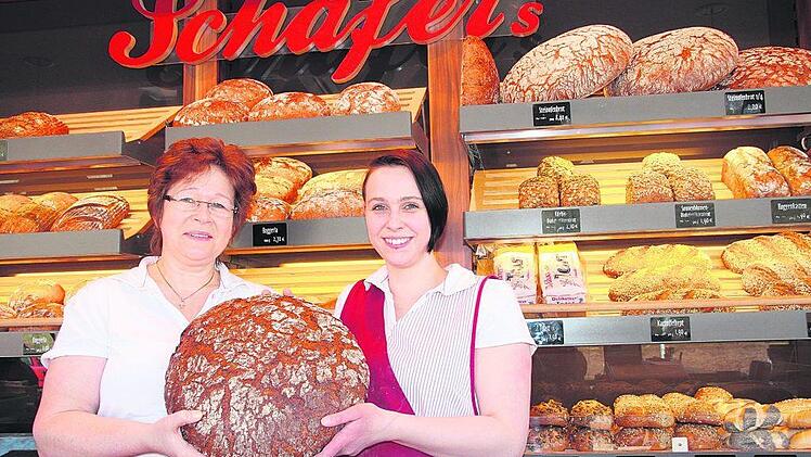 Ursula Deuber (links) und Julia Schmidt präsentieren ein Steinofenbrot der Bäckerei Schäfer. Foto: PR