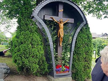 Unter einer über 200 Jahre alten Linde mitten in Berglesdorf steht dieses Holzkreuz mit Metallcorpus, über dem sich ein geschweiftes Blechdach wölbt. Foto: Heike Schülein