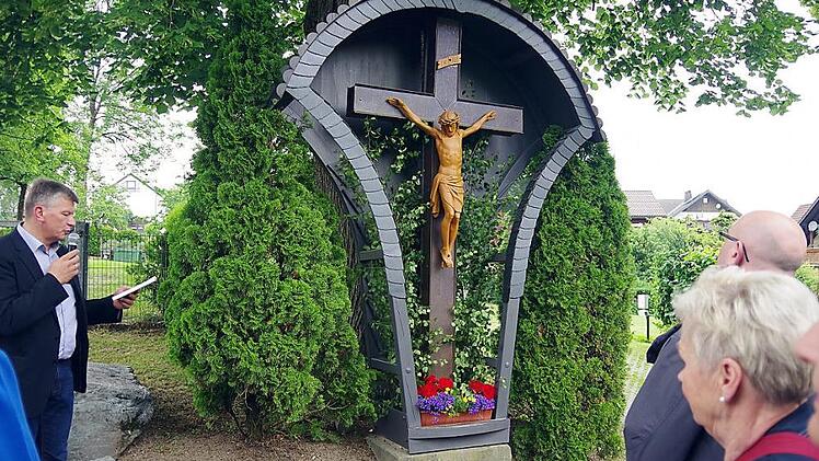 Unter einer über 200 Jahre alten Linde mitten in Berglesdorf steht dieses Holzkreuz mit Metallcorpus, über dem sich ein geschweiftes Blechdach wölbt. Foto: Heike Schülein