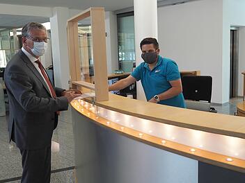 Plexiglasscheiben im SÜCenter in der Bamberger Straße sowie am Theaterplatz minimieren das Infektionsrisiko, zeigt SÜC-Geschäftsführer Wilhelm Austen (links). Das vorbildliche Pandemiemanagement des Coburger Versorgungsunternehmens bestätigt jetzt ein Zertifikat des Verbandes der Bayerischen Energie- und Wasserwirtschaft.  Foto: Christoph Winter