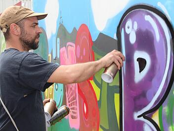 Künstler Philipp Katzenberger bei den Feinarbeiten  für das Kindergarten-Graffiti. Foto: Julia Raab