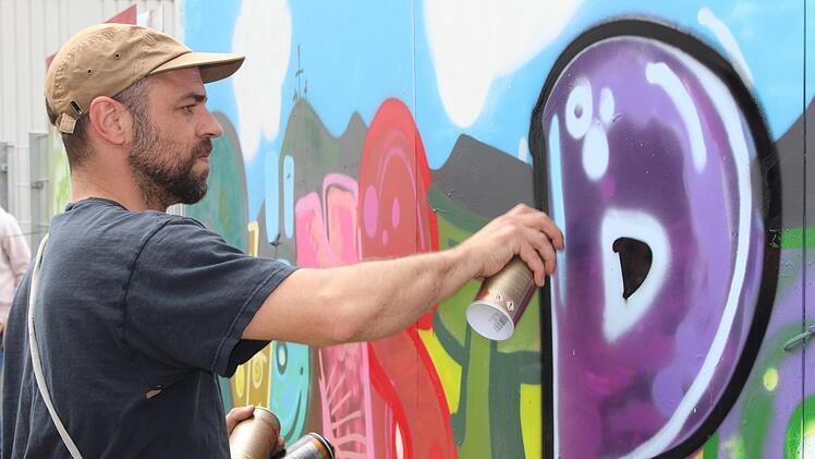 Künstler Philipp Katzenberger bei den Feinarbeiten  für das Kindergarten-Graffiti. Foto: Julia Raab