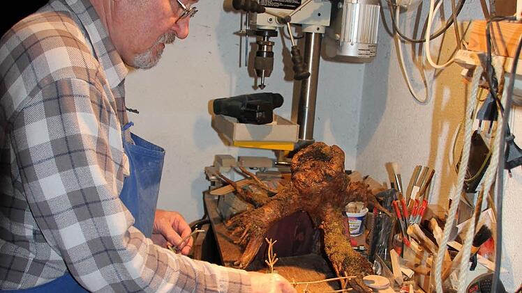 Halb "Meister Eder", halb Werklehrer: Armin Dominka bestückt eine Wurzel-Krippe mit neuen Zäunen. Foto: Ralf Kestel