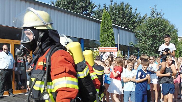Die Atemschutzträger begeben sich in das Schulgebäude. Foto: Petra Malbrich