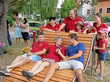 Die neue Gartenliege auf dem Meedensdorfer Brunnenplatz gefiel auch dem Team vom Bayerischen Rundfunk. Im Bild Redakteur Moritz Pompl auf der Liege im Gespräch mit Christel Klötzscher, der Sponsoren-Beauftragten der "Herzplatz"-Aktion. Foto: Andrea Spörlein