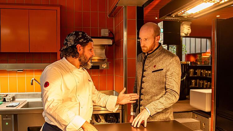 Restaurant-Inhaber Franz-Josef Penkofer (Lukas Turtur, rechts) pflaumt Maximilian Dobek (Manuel Cortez) an, weil sich mal wieder ein Gast &uuml;ber dessen Essen beschwert hat.