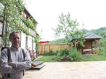 Eckert Henzler am Eingang zu seinem Hof in Erlach. Den Pavillon hat er zum Beispiel selbst mit Schiefer eines Thüringer Abrisshauses gedeckt. Foto: Popp