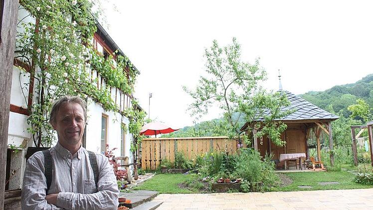 Eckert Henzler am Eingang zu seinem Hof in Erlach. Den Pavillon hat er zum Beispiel selbst mit Schiefer eines Thüringer Abrisshauses gedeckt. Foto: Popp